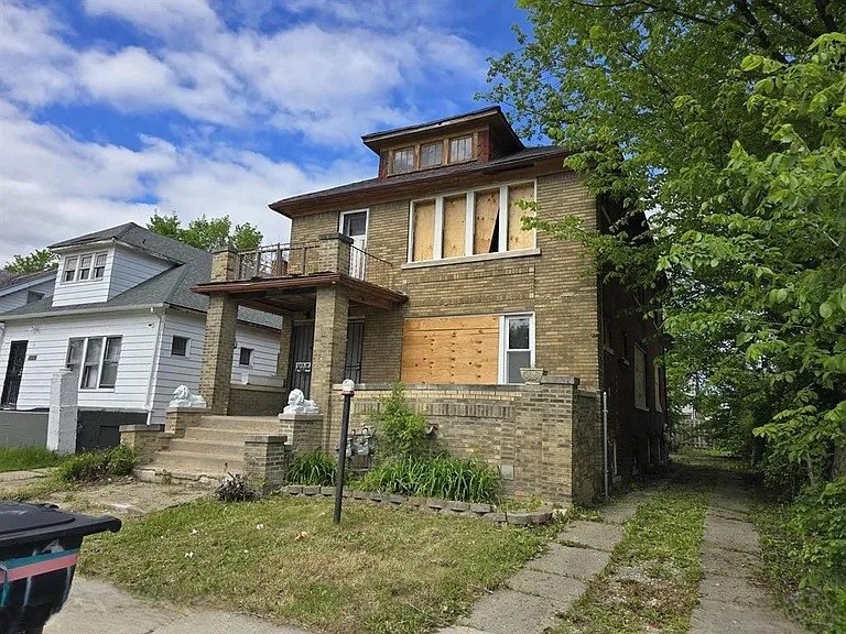Distressed boarded-up property before renovation by Monvestor Construction Group