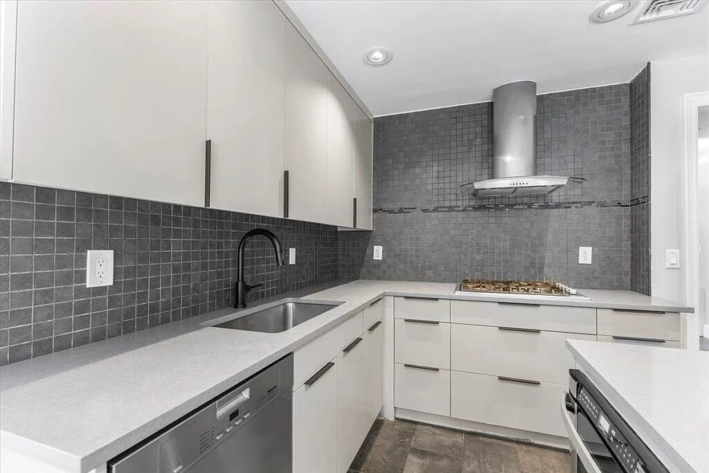 Kitchen with a grey tile backsplash and stainless appliances