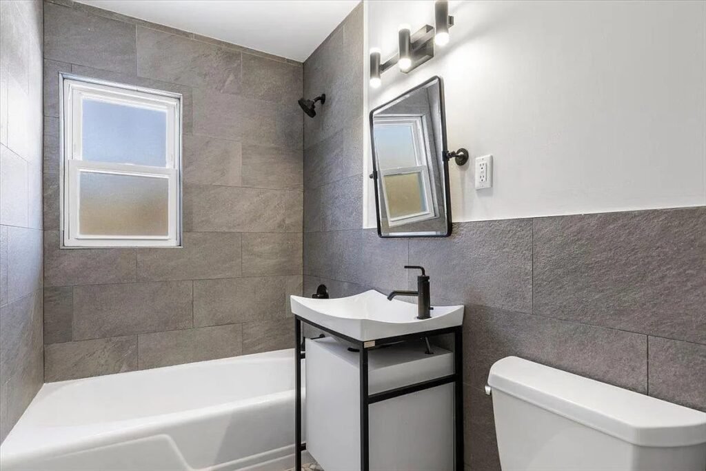 Renovated bathroom with a tub and large-format tile