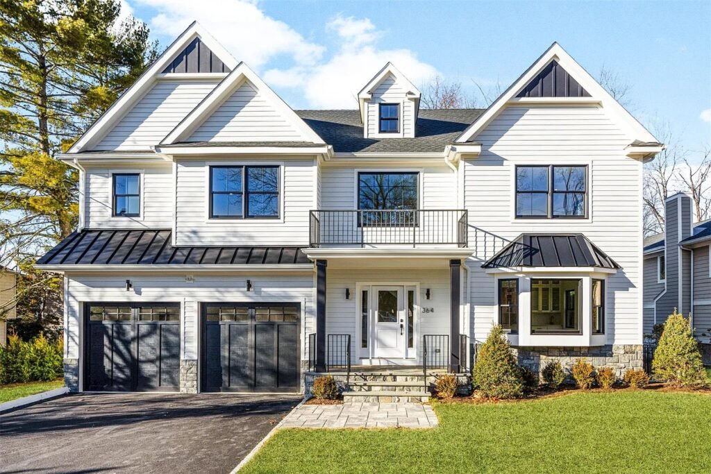 Completed custom home exterior with dark trim and manicured lawn