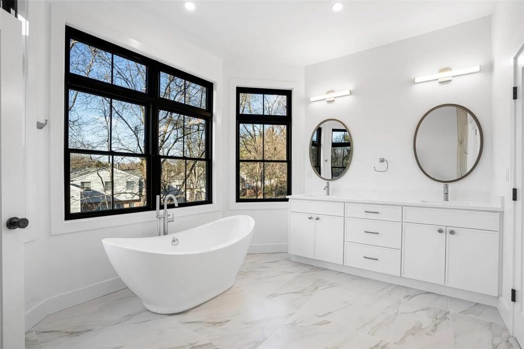 Primary bath with marble tile and a freestanding tub