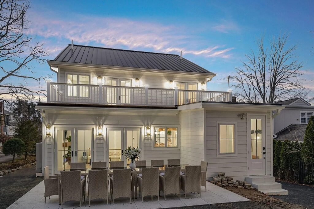 Rear elevation at dusk with a covered deck and outdoor dining