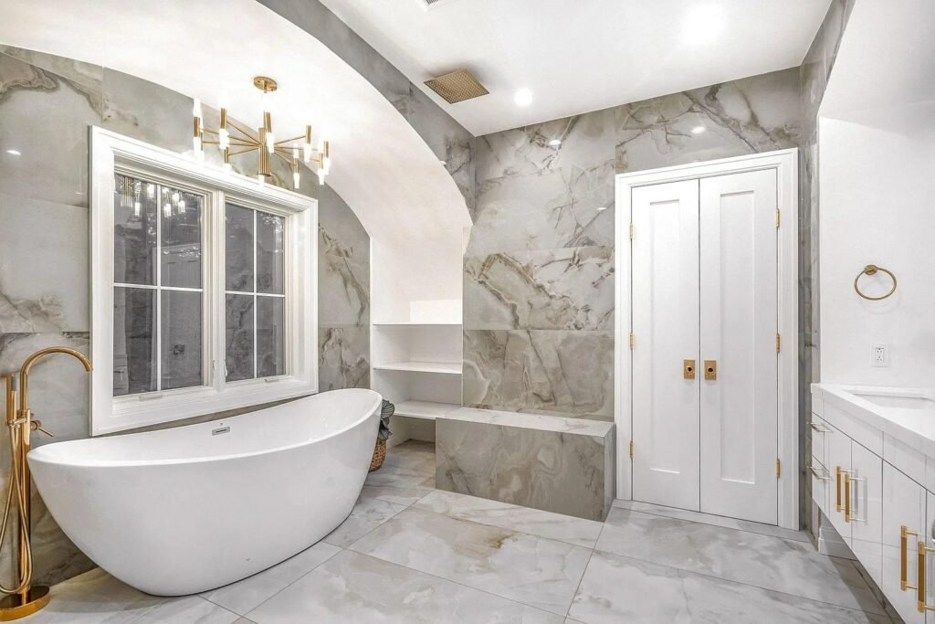 Primary bathroom with a freestanding tub and marble surround