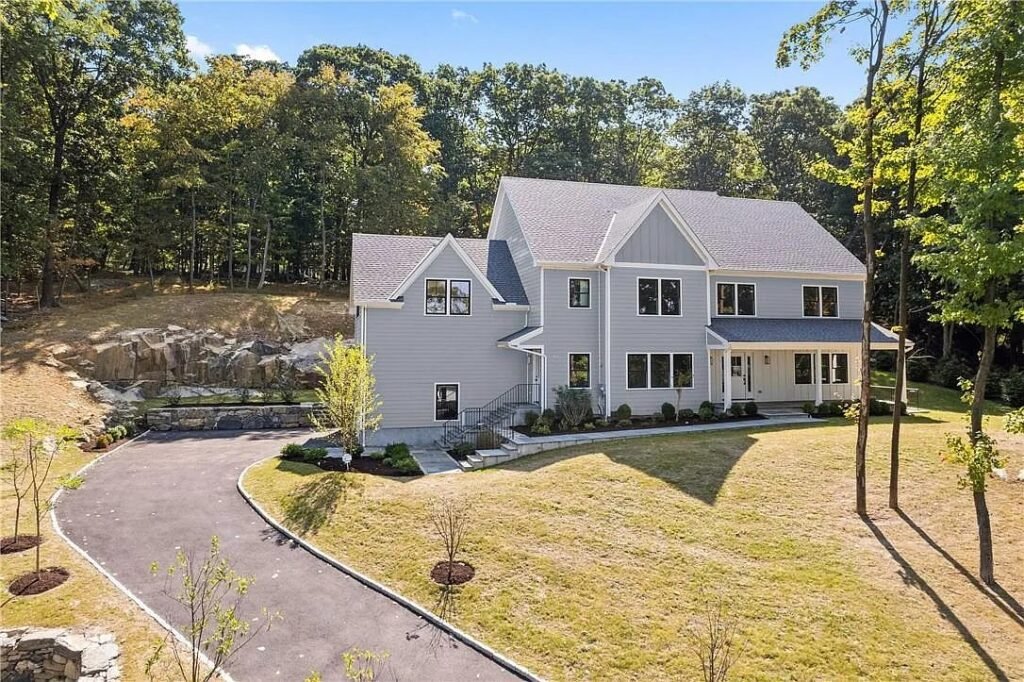 The Woodland Ledge House front elevation with a paver driveway