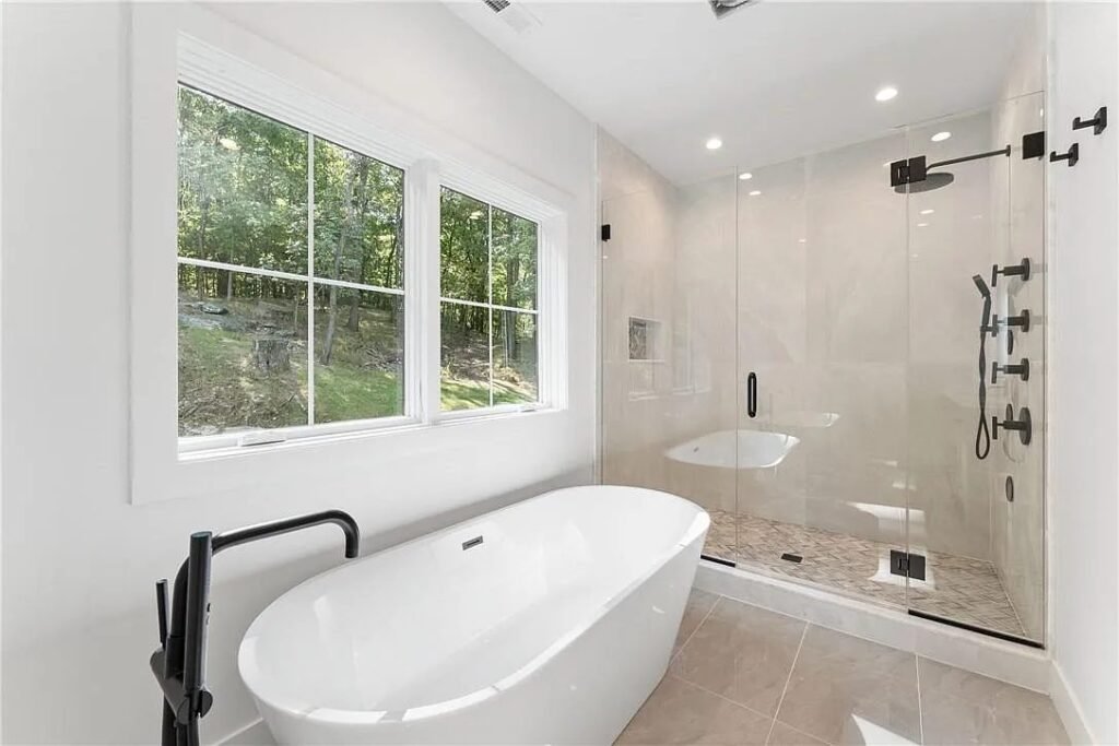 Primary bathroom with a freestanding tub beneath a window