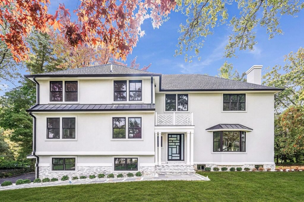 White colonial exterior framed by autumn trees