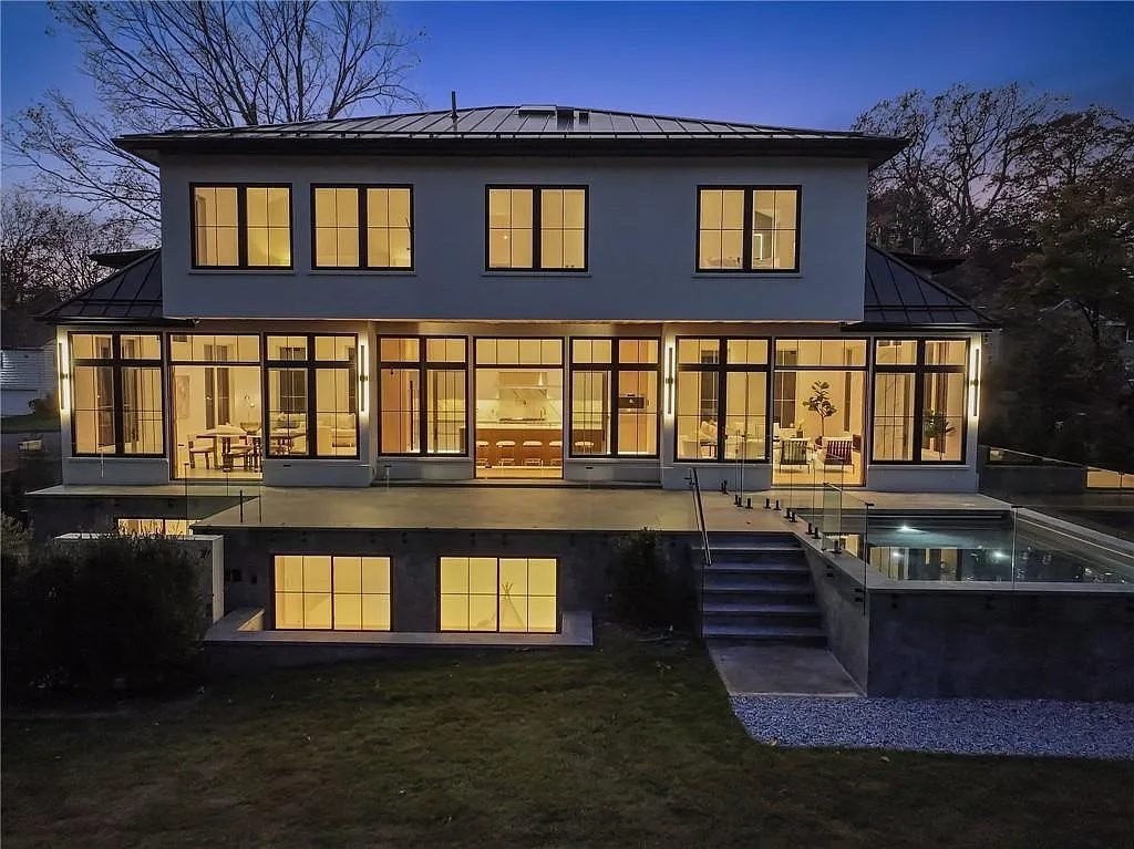Rear elevation at twilight with full-height windows glowing