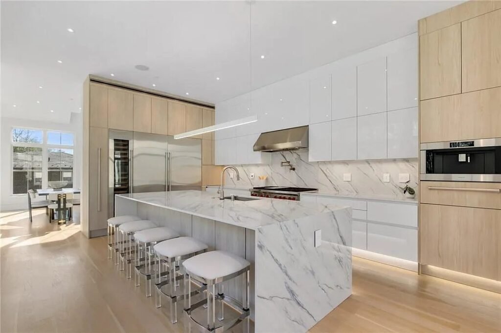 Marble kitchen with a waterfall island and integrated appliances