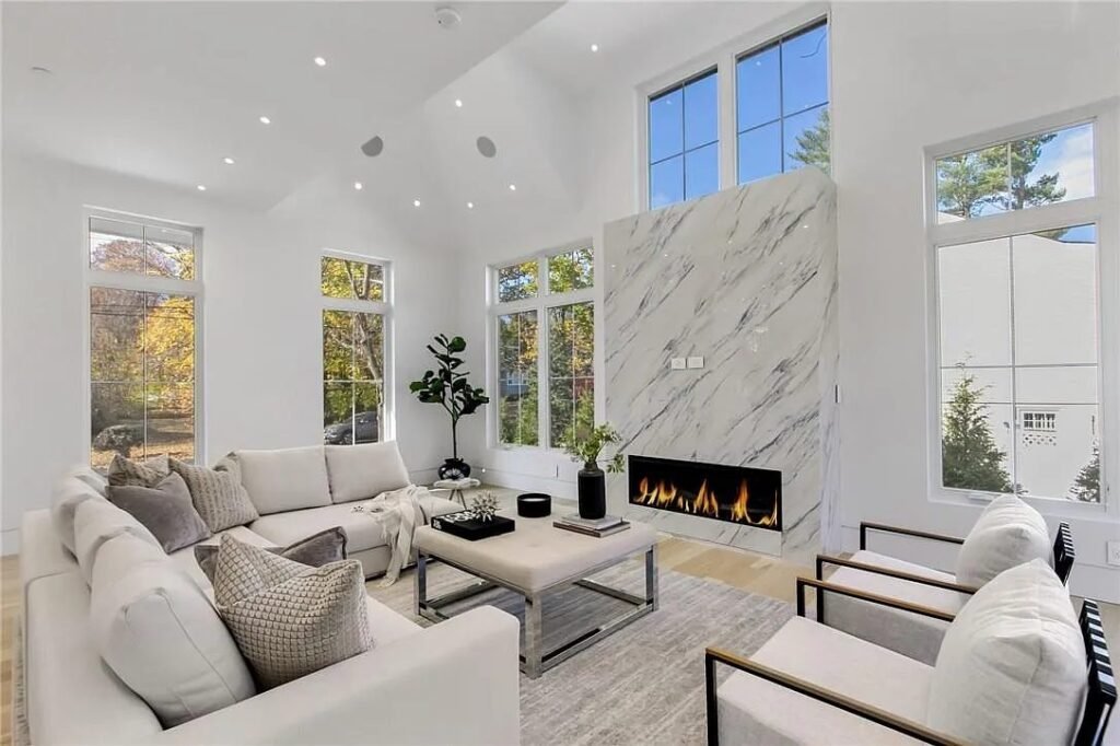 Living room with a linear fireplace and stone surround