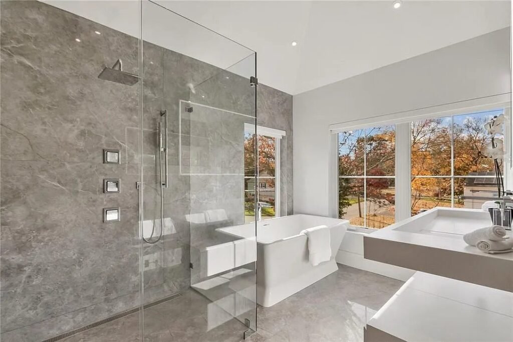 Primary bathroom in large-format stone with a glass shower