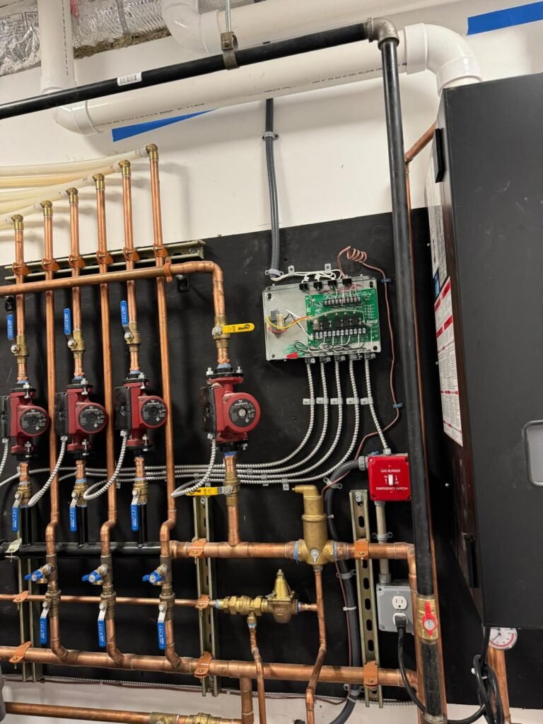 Plumbing manifold with red and blue PEX supply lines installed in a new build