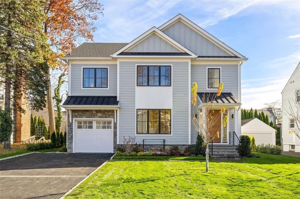 The Coffered Residence front elevation with white siding and a covered entry