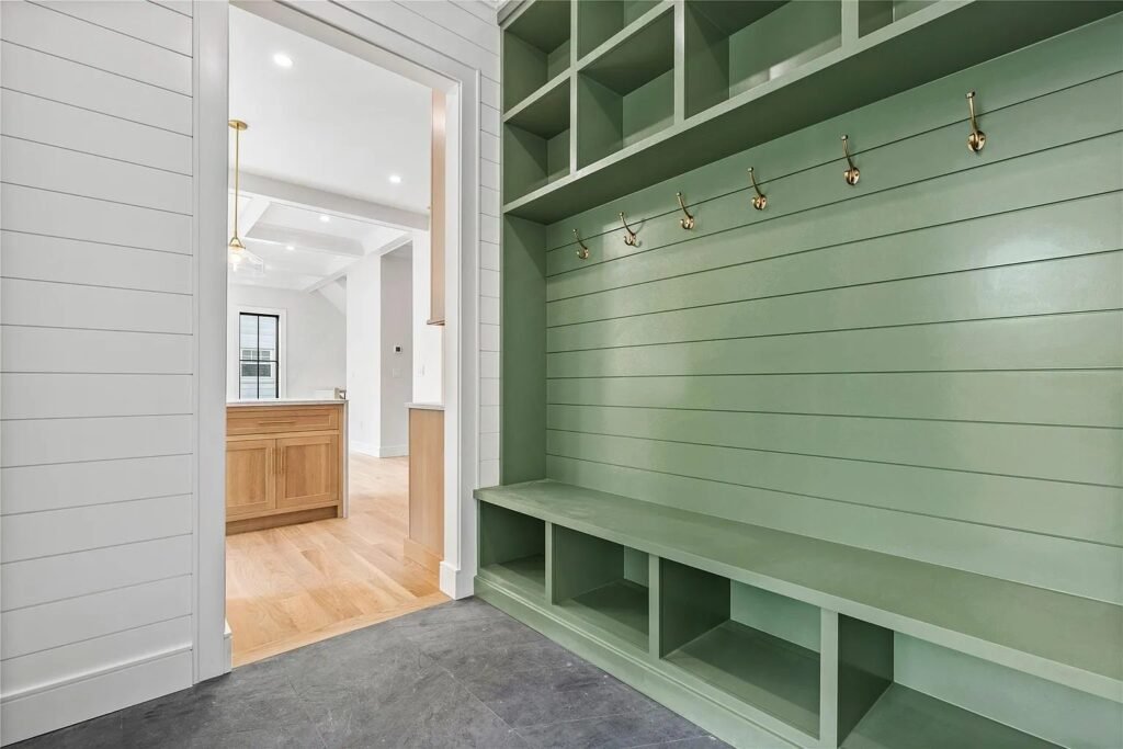 Mudroom with green shiplap panelling and a built-in bench